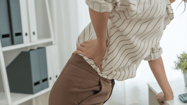 Asia beautiful woman holding her lower back while and suffering from unbearable pain health and problems, chronic back pain, backache in office syndrome, scoliosis, herniated disc, muscle inflammation